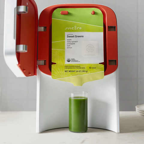 La presse Juicero ouverte, un verre de jus vert
